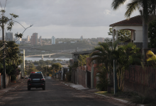 Viatura policial em área urbana de fronteira entre Brasil e Paraguai, com composição editorial sem identificação de pessoas ou documentos