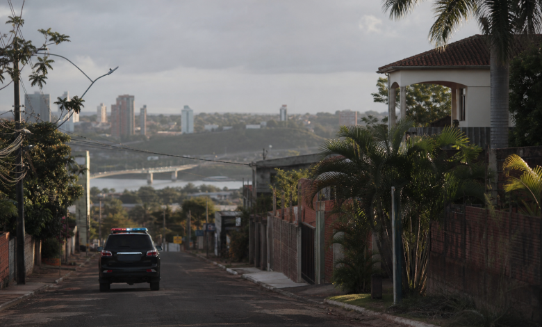 Viatura policial em área urbana de fronteira entre Brasil e Paraguai, com composição editorial sem identificação de pessoas ou documentos