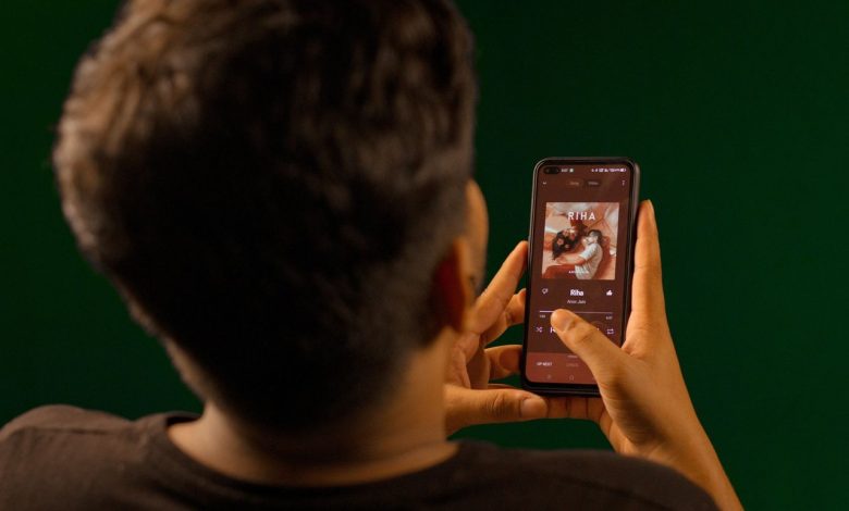 Pessoa usando um smartphone para reproduzir conteúdo em um aplicativo de streaming.