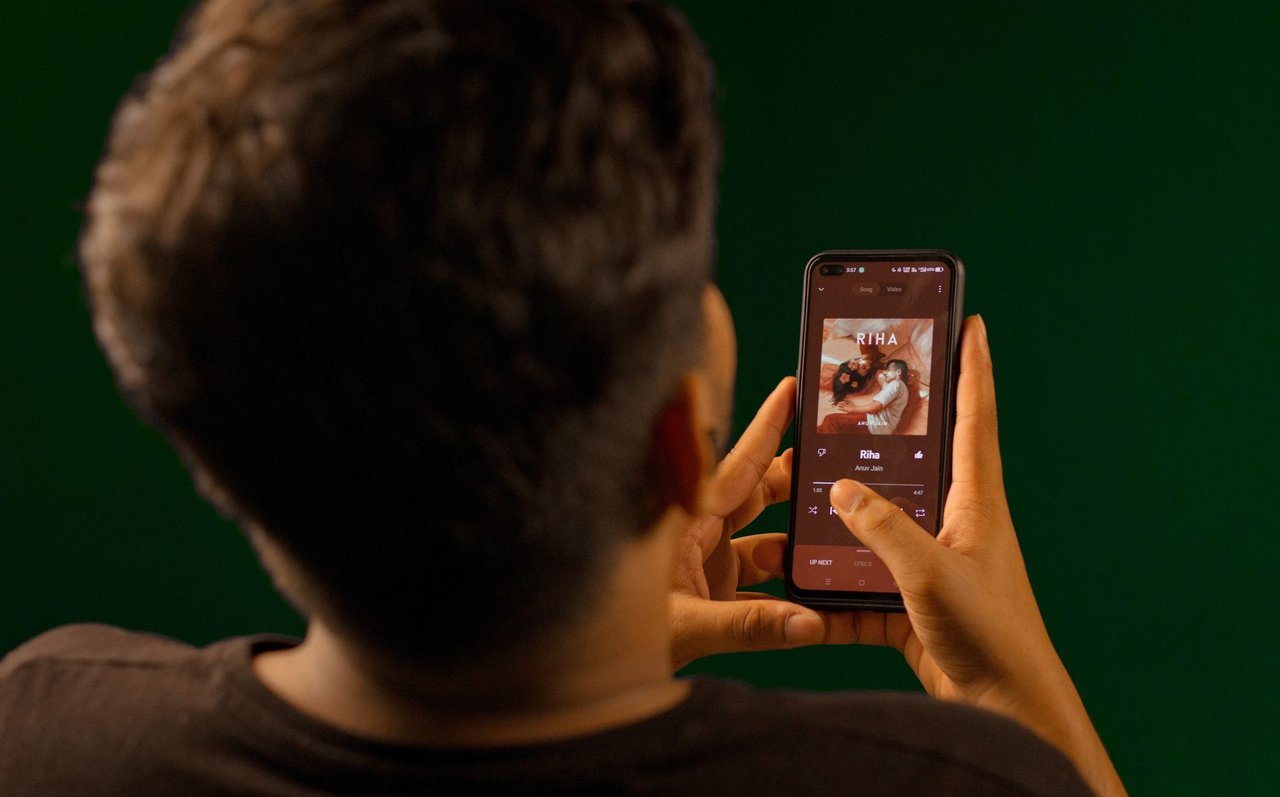 Pessoa usando um smartphone para reproduzir conteúdo em um aplicativo de streaming.
